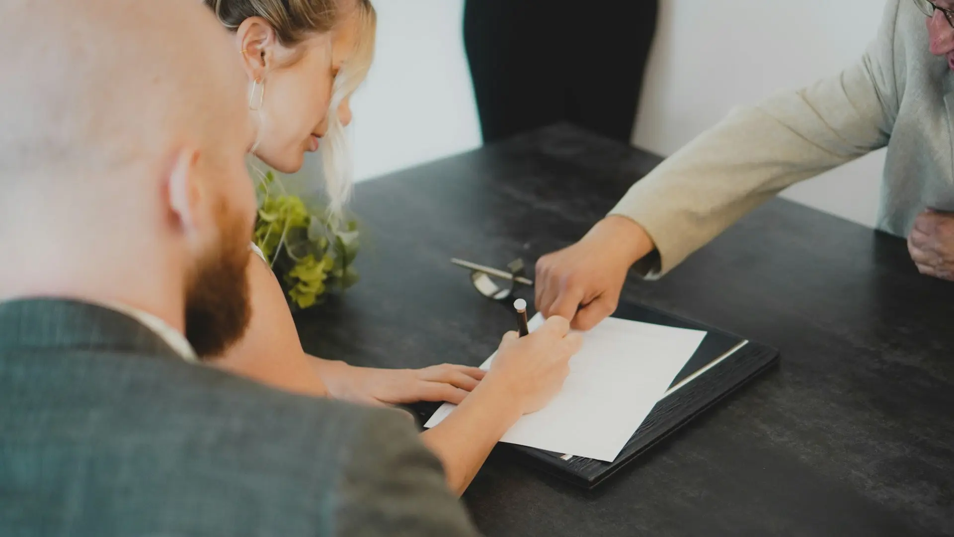 a woman showing a man something on a tablet